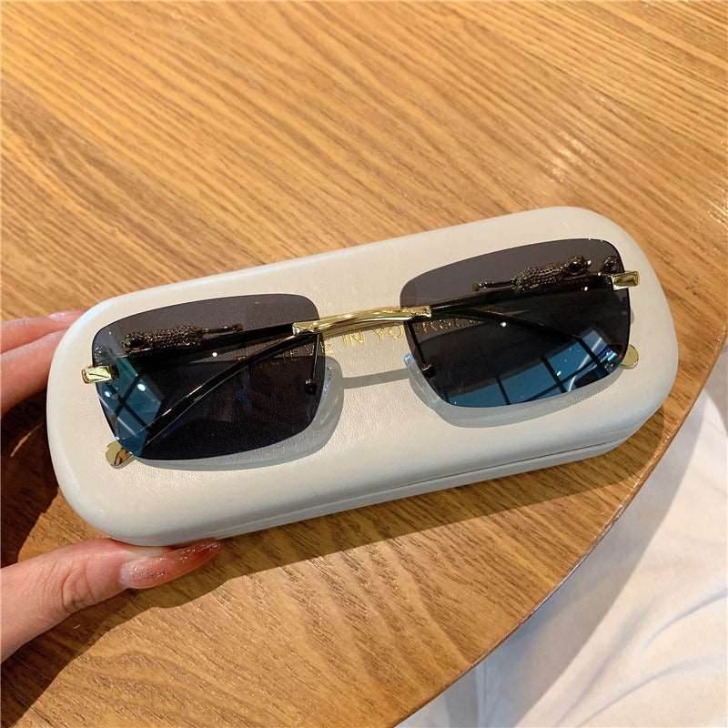 trendy rimless sunglasses for women Sunglass Lover rectangular dark lenses gold bridge on white case