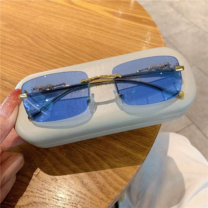 Sunglass Lover trendy rimless sunglasses for women blue tinted rectangular lenses with gold accents on white case