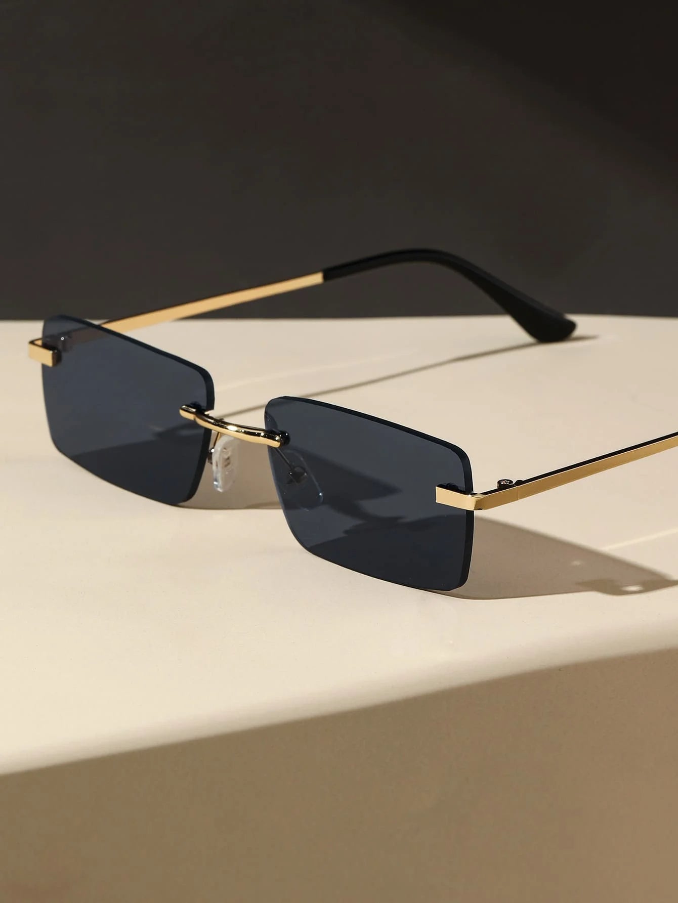 Bondex rimless sunglasses by Sunglass Lover with dark rectangular lenses and gold temples