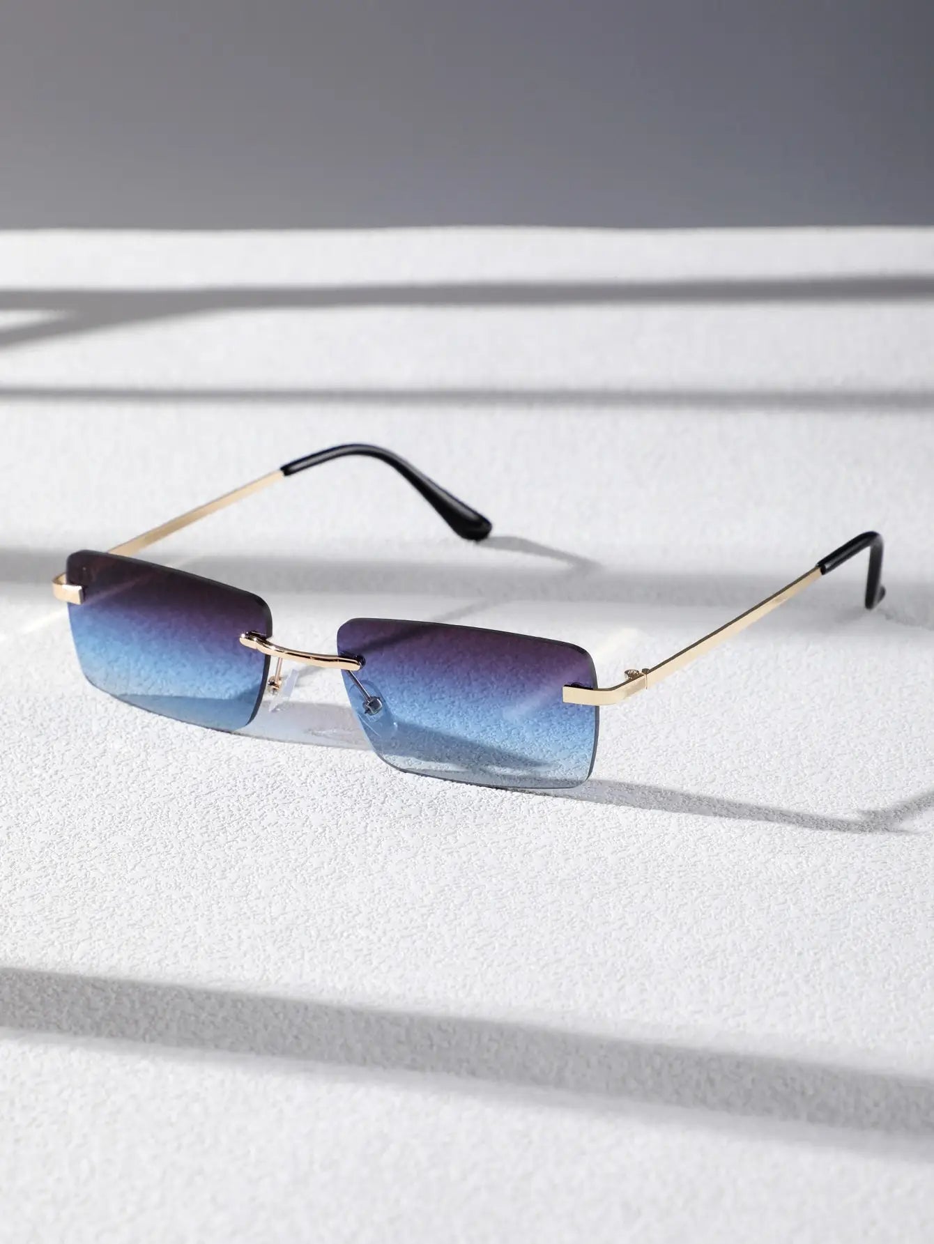 Bondex rimless sunglasses with blue gradient lenses and gold thin metal frames by Sunglass Lover
