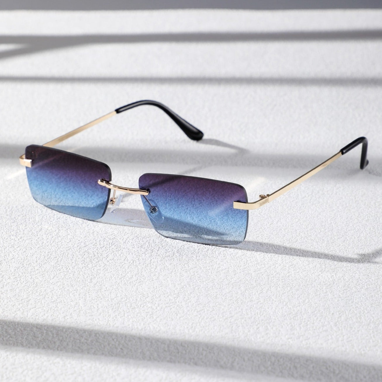 Bondex rimless sunglasses with blue gradient lenses and gold metal temples by Sunglass Lover