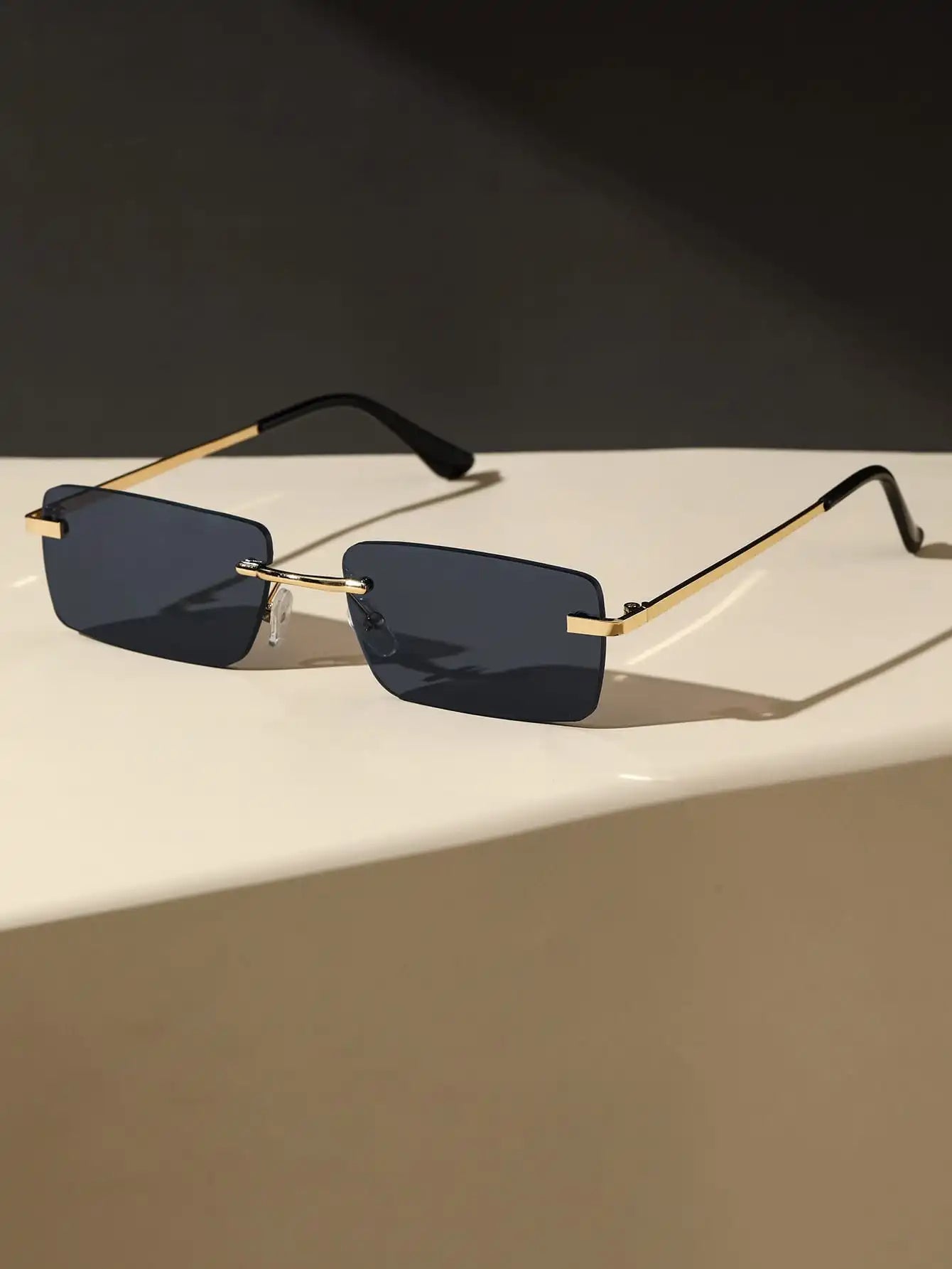 Bondex rimless sunglasses with rectangular dark lenses and gold-tone arms by Sunglass Lover