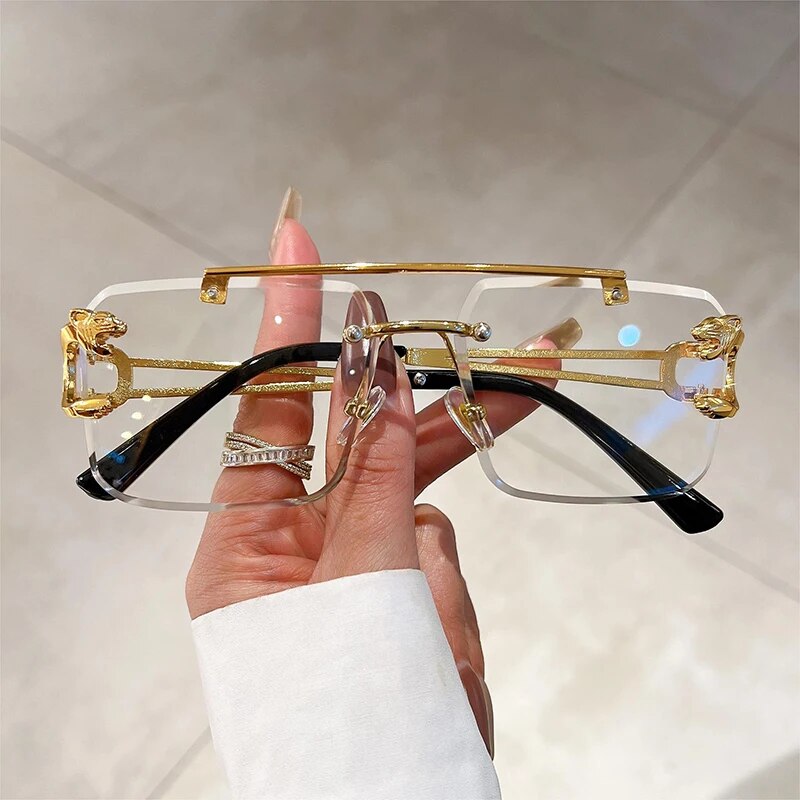 Jim Jack double bridge sunglasses rimless style with gold and black accents held in hand