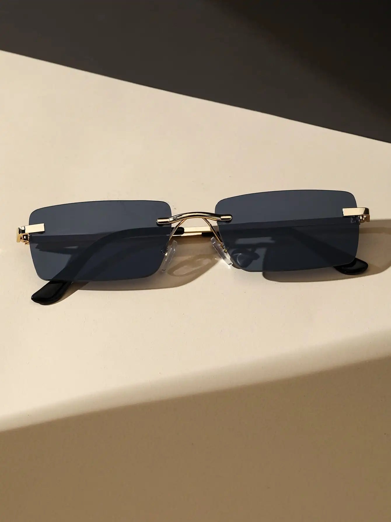 Bondex rimless sunglasses with dark rectangular lenses and gold frame accents by Sunglass Lover