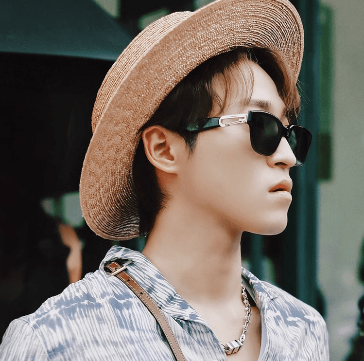 Sunglass Lover model wearing retro cat eye sunglasses for women black frames with straw hat and patterned shirt
